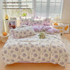 A lavender floral duvet cover set displayed on a bed with pillows and accessories.