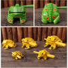 Handcrafted wooden frog guiro rasp percussion instrument in various shades of green and yellow.