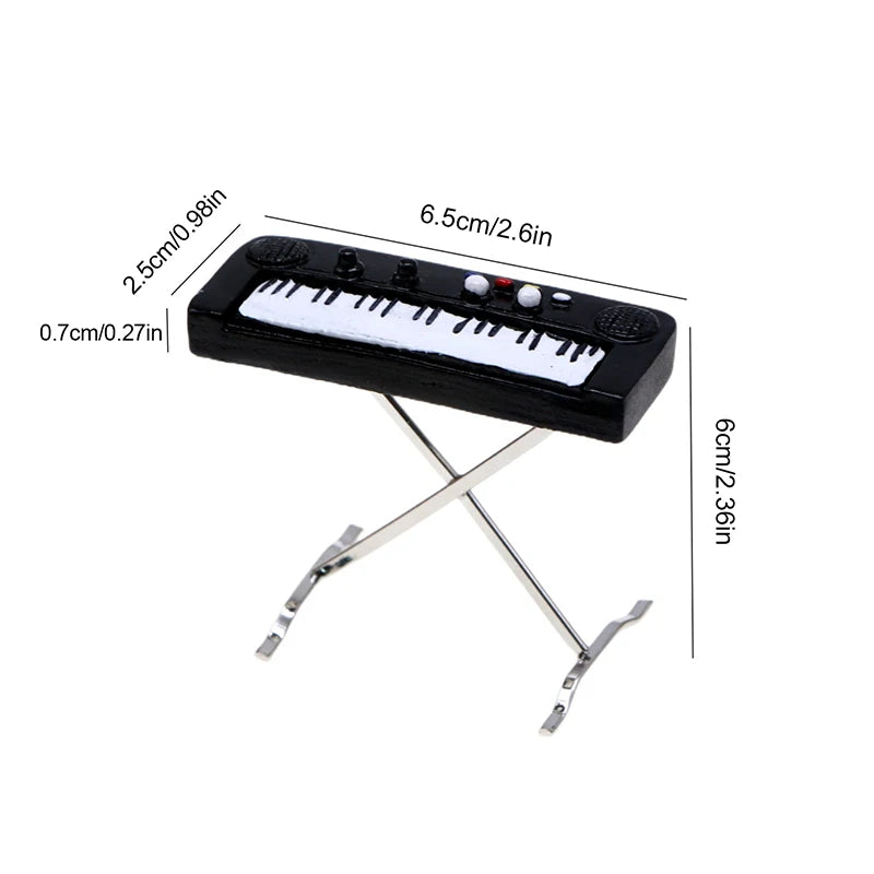 A black 1:12 scale dollhouse piano with a bench, featuring white keys and decorative buttons.