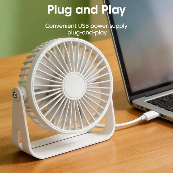 Ein weißer Plug-and-Play-USB-Schreibtischventilator neben einem Laptop.
