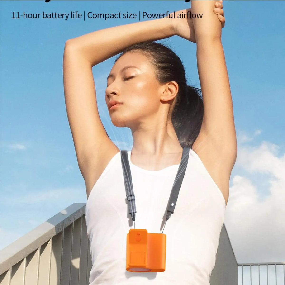 A woman holds a portable clip-on fan with an orange LED display against a blue sky.
