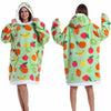 Eine Frau modelliert einen hellgrünen Patchwork-Fleece-Hoodie mit bunten Frucht-Designs.