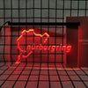 A neon sign shaped like the map of Nuremberg in bright red light displayed against a black grid background.
