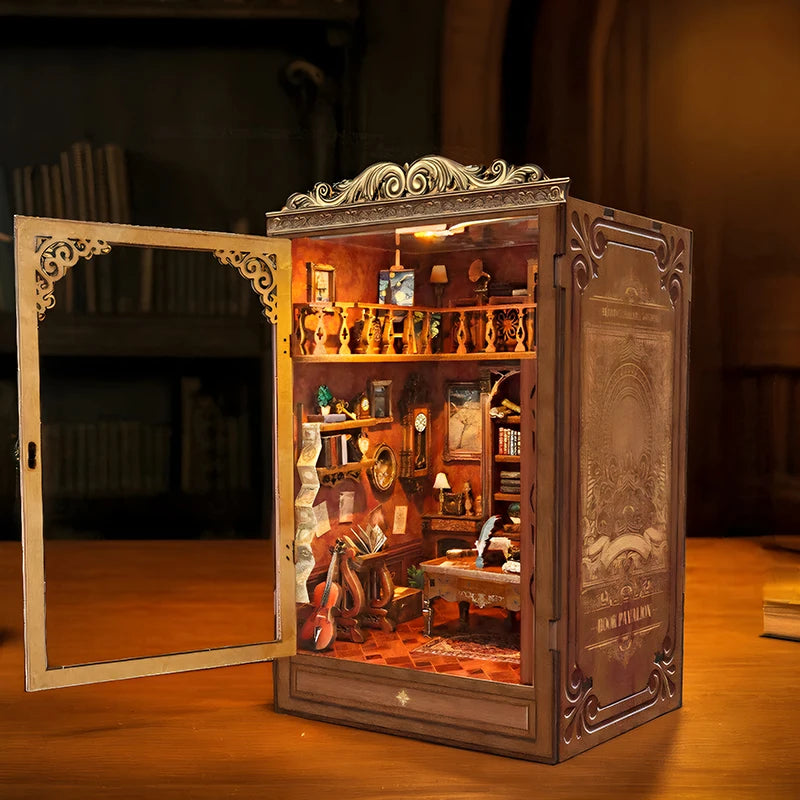 A detailed miniature book house shelf insert featuring wooden shelves, books, and decorative items within a framed box.