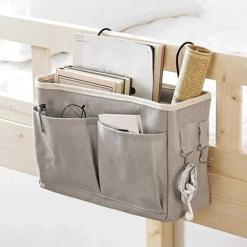 A beige hanging storage organizer with cotton pockets is displayed on a wooden shelf.