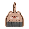 A compact cartoon broom and dustpan set in a matte pink color for desk and tabletop cleaning.