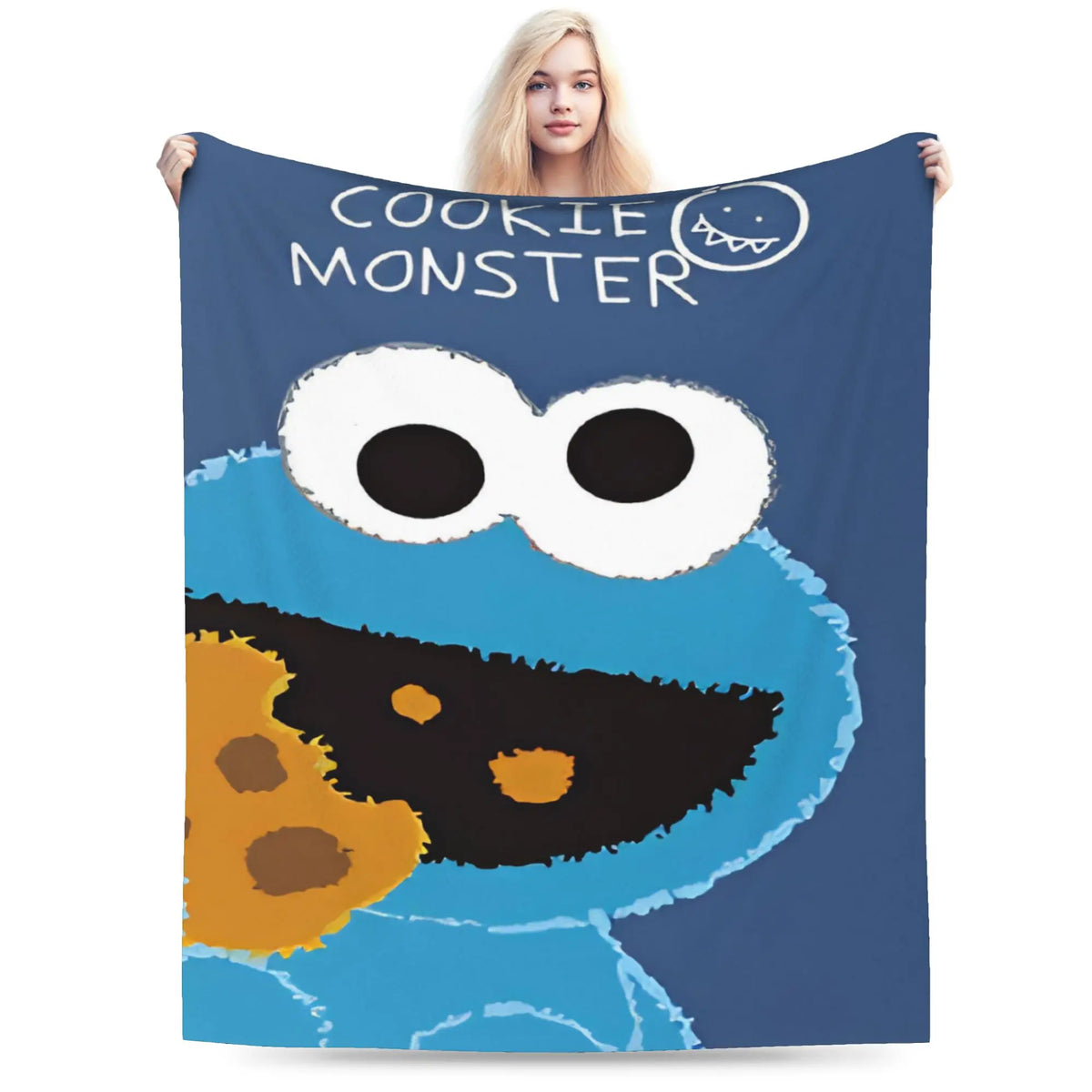 A dark blue blanket featuring a cartoon cookie monster face with large eyes and orange and black features.