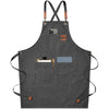 A dark gray cotton canvas apron with black cross-back straps and multiple pockets.