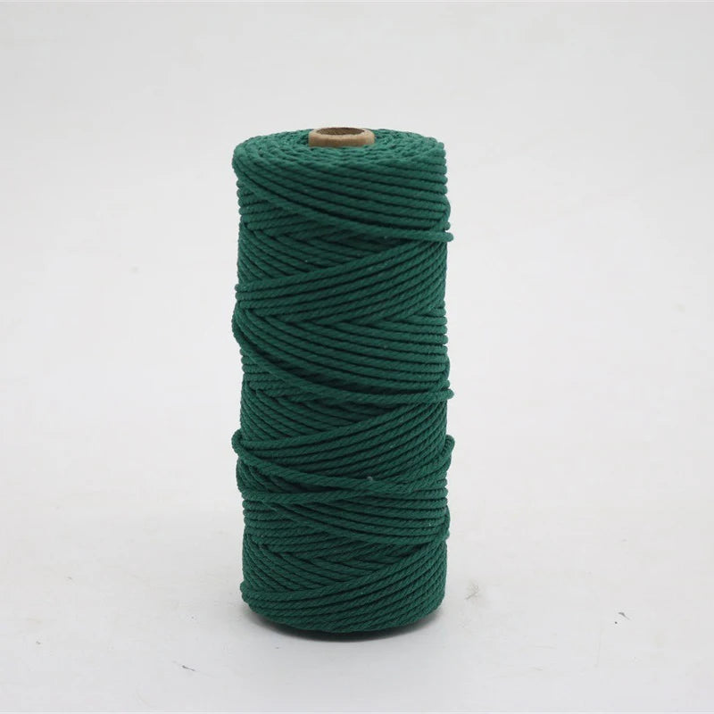 A spool of dark green macrame cord, 3mm/4mm thickness, used for crafting.