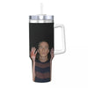 A black insulated stainless steel tumbler with a silver lid and a person's face visible through the material.