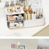 A white desk organizer with transparent drawers holding various perfume bottles and cosmetic items.