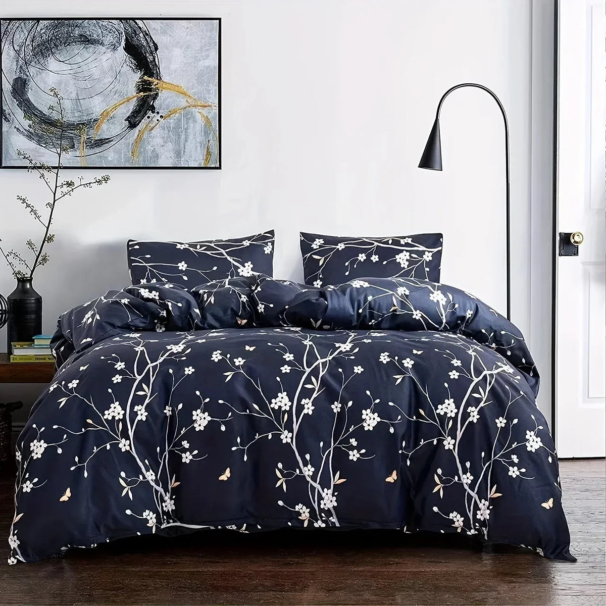 A dark blue duvet cover set with a white floral pattern displayed on a bed.