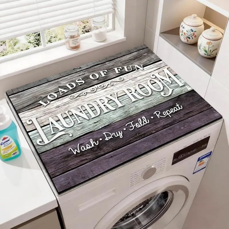 A laundry room features a washing machine with a wooden mat engraved with the words Loads of Fun Laundry Room Wash Dry Fold R