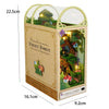 A wooden DIY book nook kit featuring a miniature firefly forest scene inside a glass display box.