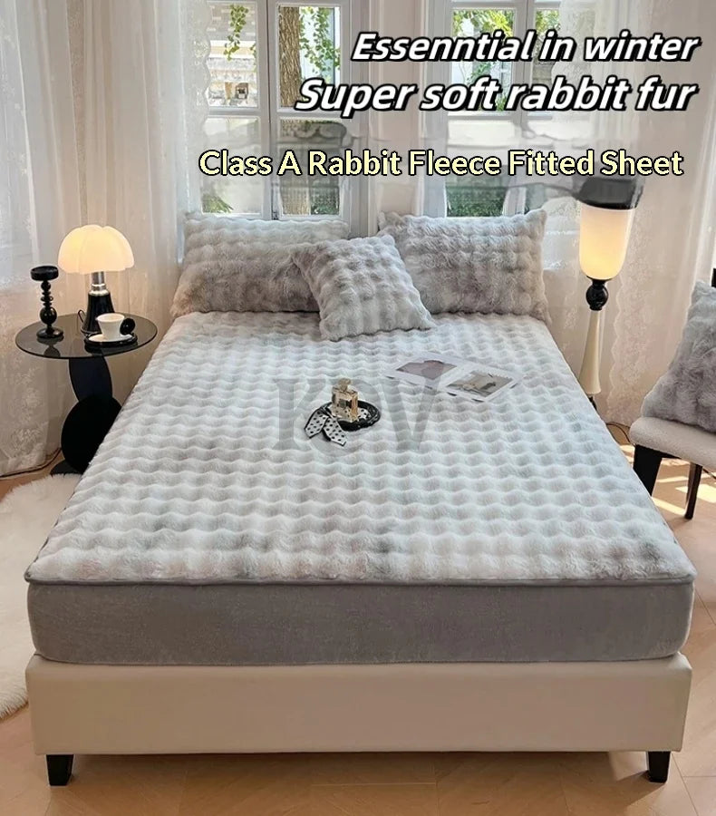 A gray rabbit fur fleece fitted sheet and pillowcase set displayed on a bed with natural light.