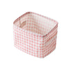 A pink checkered cotton and linen storage basket with a square shape.
