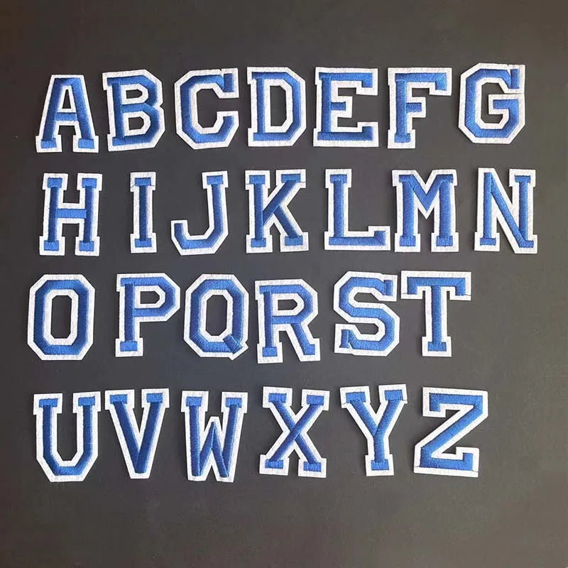 A set of embroidered alphabet letters A through Z in blue and white for iron-on patches.