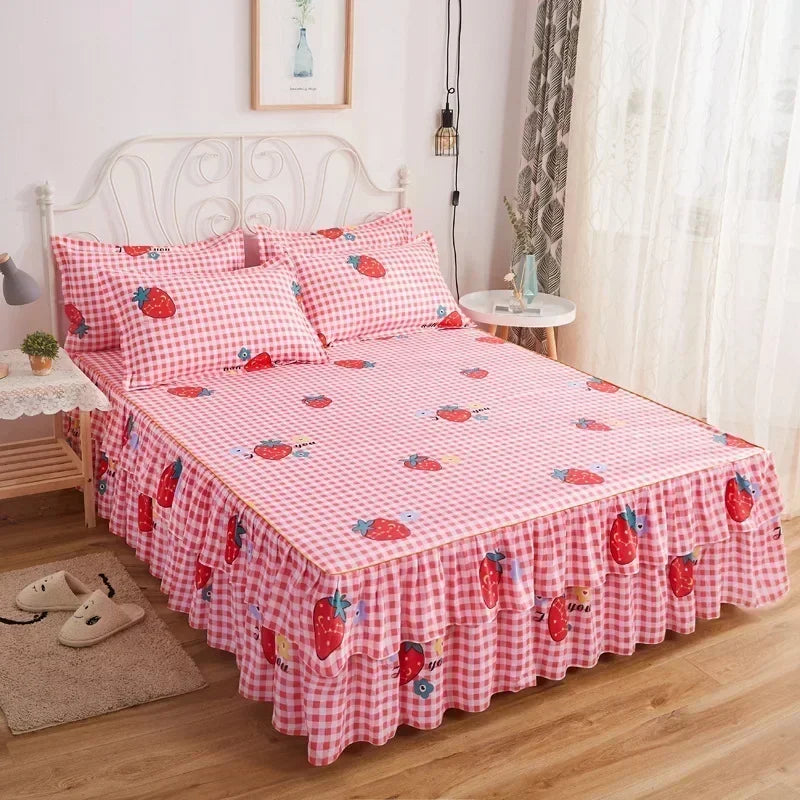Un jupon de lit à carreaux rose et blanc avec des motifs de fraises sur une tête de lit et une literie en métal blanc.
