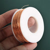 A hand holds a roll of bare copper wire with multiple diameters, showing the coiled metal strands and white plastic spool.