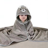 A gray hooded baby bathrobe towel with a cartoon bear face is draped on a surface.