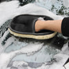A hand wearing a black microfiber car wash glove is shown cleaning a car surface covered in foam.