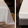 Luxuriöses Bambus-Bettwäsche-Set auf einem Tisch mit weißen Laken und Dekorationen.