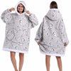 Eine Frau modelliert einen grauen, lappigen, oversized Fleece-Hoodie mit Kapuze und einem Muster aus kleinen Vogelgrafiken.