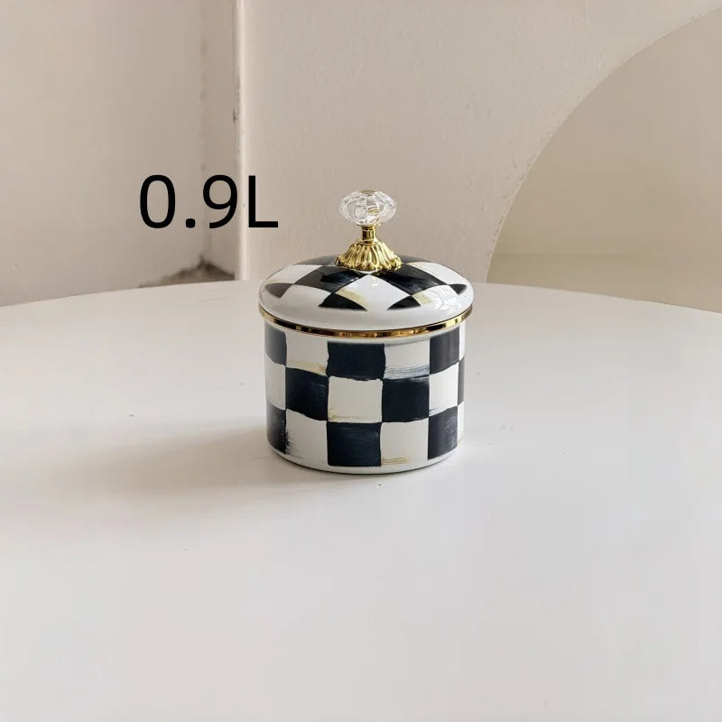 A small 0.9L checkerboard porcelain storage jar with a gold lid sitting on a white surface.