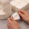 Hands are using lint-free cotton rounds for nail care, demonstrating the product texture and use.