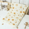 A beige cartoon bear stroller cushion with sun and rainbow patterns resting on a white surface.