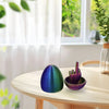 A purple and blue egg and a purple hand decorated with nails used as desk decor