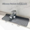 A silicone faucet splash mat is placed on a countertop, designed to catch water from a faucet.