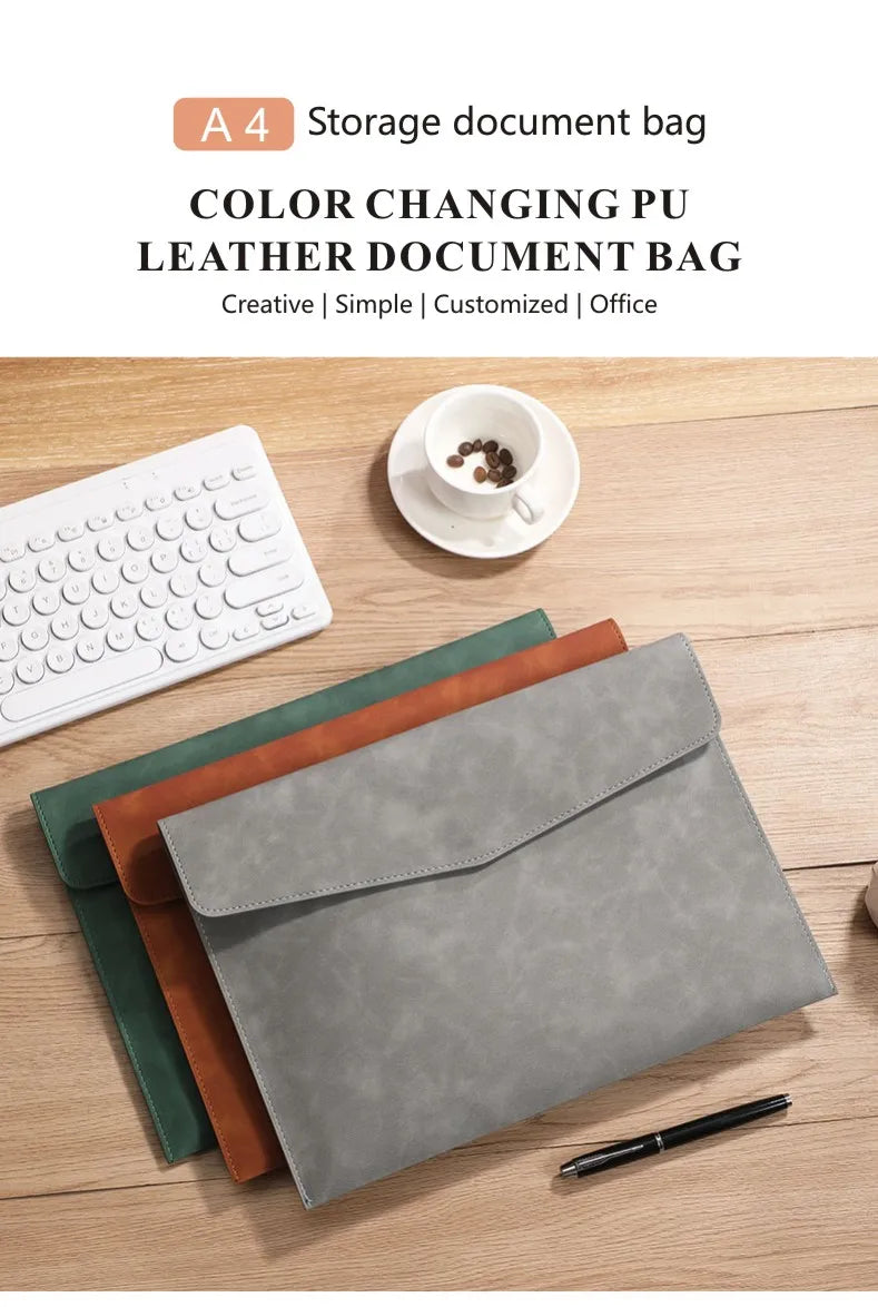 Pochette de document A4 en cuir PU gris à côté d'un ordinateur portable et d'un stylo sur une table en bois.