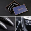 A set of ultra-thin carbon fiber steering wheel covers displayed in a wooden box and on a dark surface.