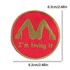 Red embroidered patch featuring a gold letter M and the text I'm loving it