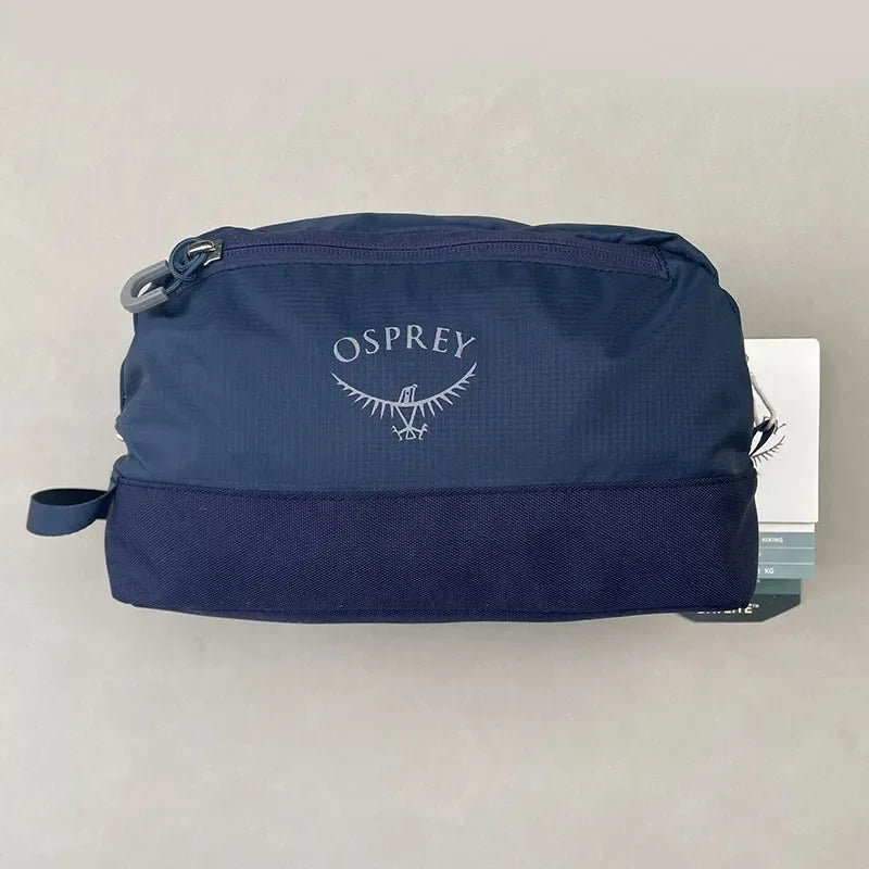 Sac de toilette pliable et imperméable bleu marine Osprey avec un logo argenté.