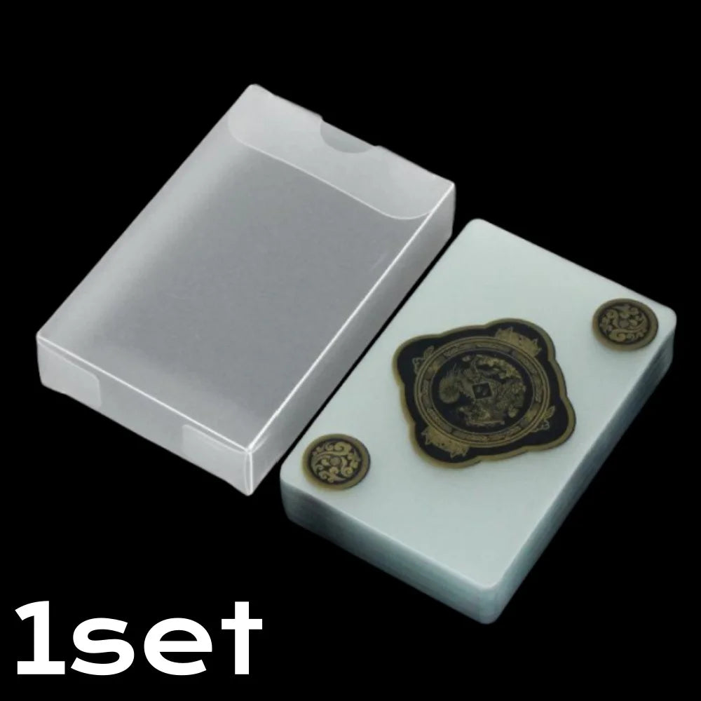 Un jeu de cartes transparentes en PVC imperméables dans un porte-cartes rectangulaire blanc avec des cartes dorées.