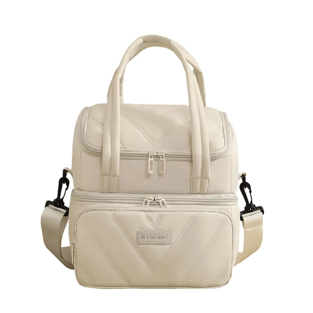 A beige insulated leakproof reusable lunch bag with a padded top and zippered compartments.