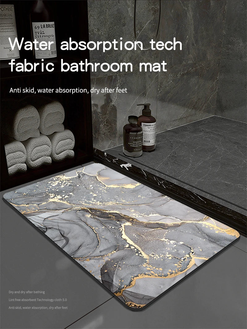A rectangular bathroom mat with a marbled gray and gold pattern is displayed on a dark surface.