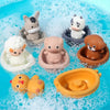A collection of silicone animal finger puppets and bath toys floating in clear water.
