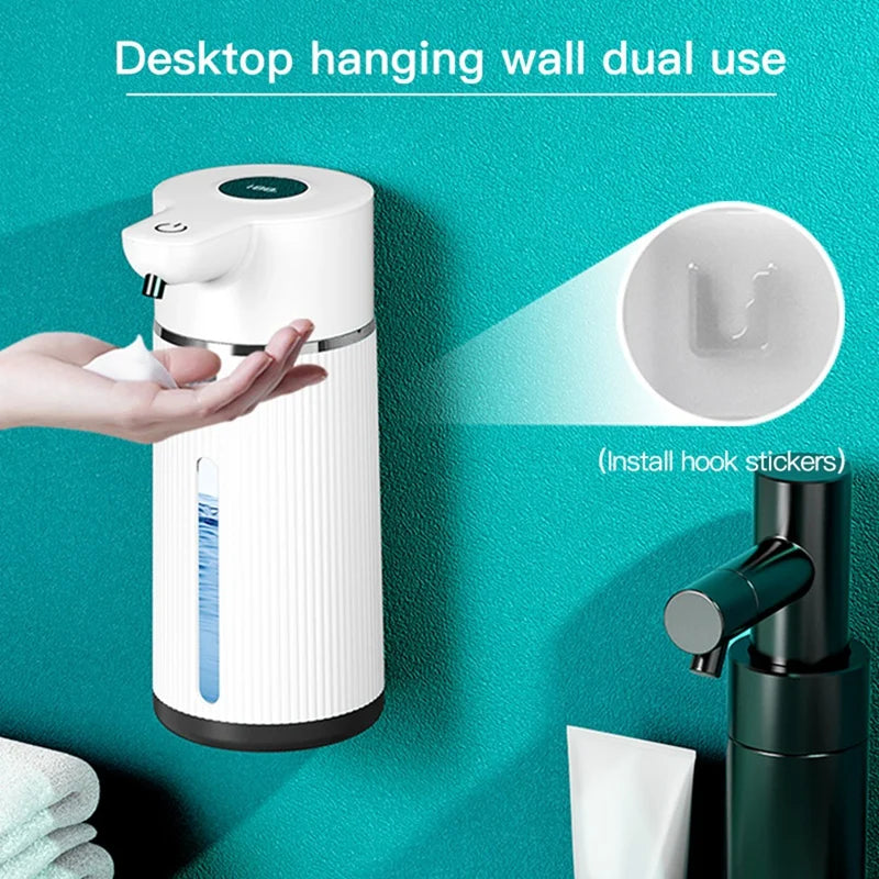 A white automatic foaming soap dispenser is shown hanging on a teal wall, demonstrating its dual use.