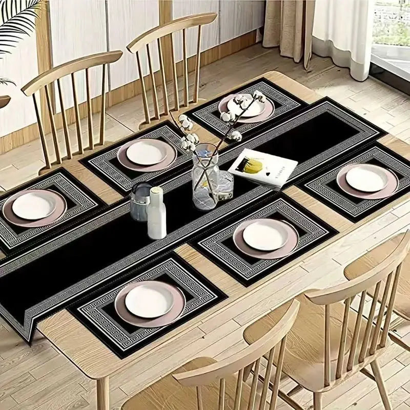 A set of waterproof geometric table runners and placemats featuring black and silver patterns on a wooden table.