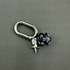 A silver heart-shaped keychain charm featuring a black and white dice with the number 15.