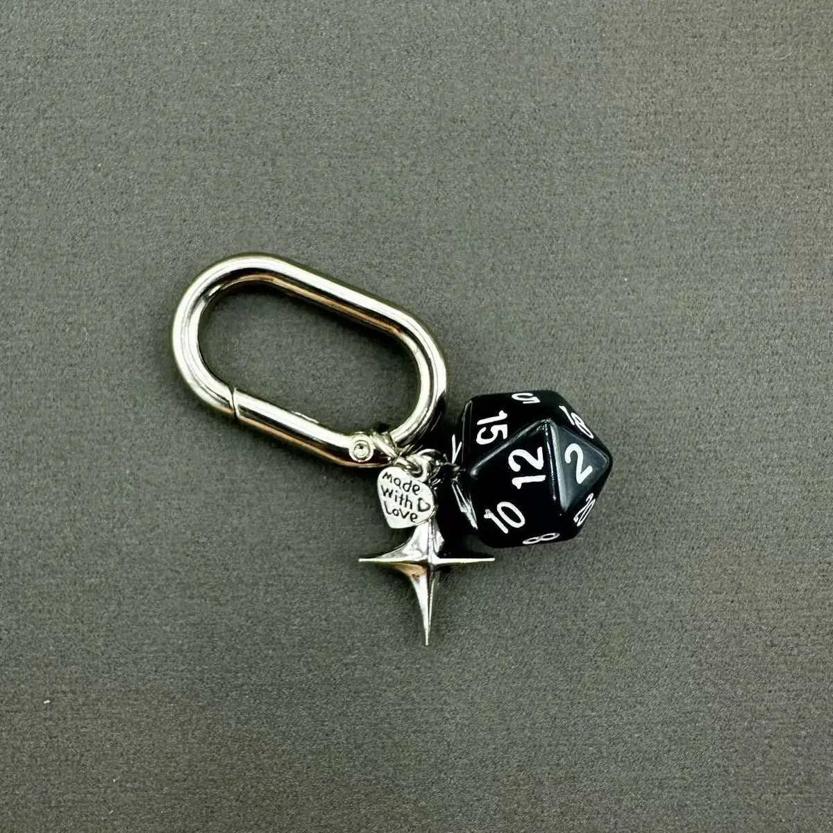 A silver heart-shaped keychain charm featuring a black and white dice with the number 15.