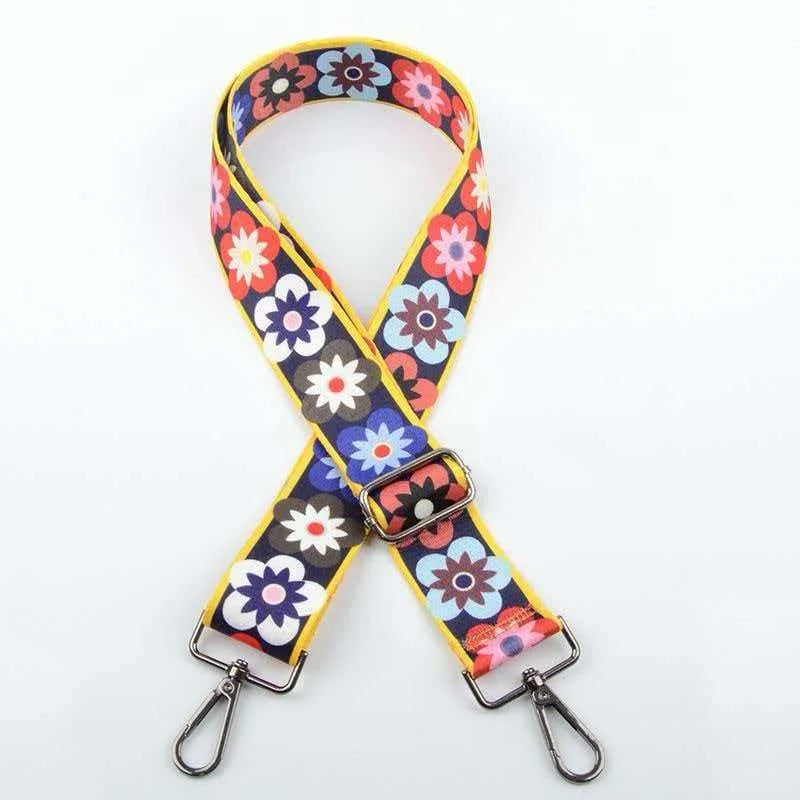 A colorful floral jacquard strap for an elegant crossbody bag, featuring yellow and purple patterns.