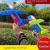 A hand holds a colorful foam aircraft gun toy with blue and red wings, ready for ejection.