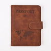 A brown leather passport holder embossed with the word PASSPORT and a world map design.