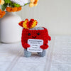 Handmade crochet dumpster fire doll with red and yellow hair and gray body for emotional support decor