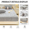 A gray plush mattress cover displayed on a bed, showing details like soft fabric and elastic bandage.