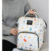 A woman holds a white and colorful patterned waterproof diaper bag backpack with black straps.
